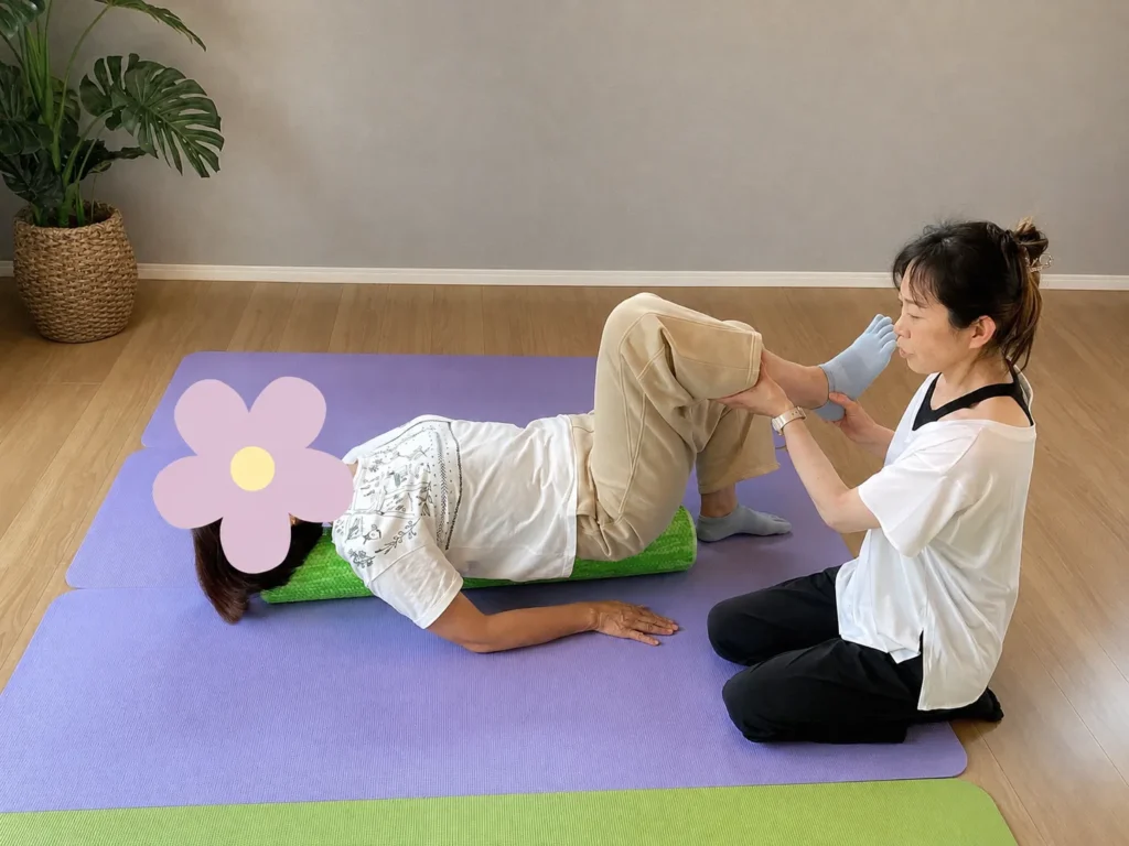 仰向けの方の脚を持ち上げ、動きを確かめている様子